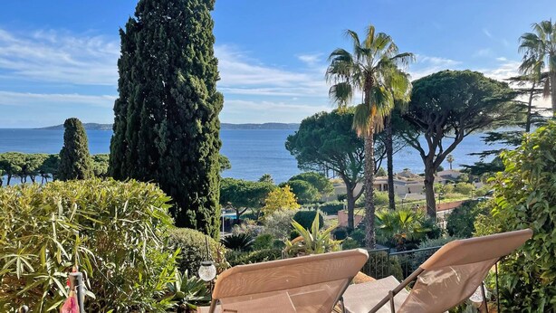 A terrace with outdoor seating, overlooking a coastal landscape with trees and a view of the sea. - Studio - 2/4 people - Sea view - AC - Residence swimming pool - Wifi - Beach - Sainte Maxime (STE MAXIME)