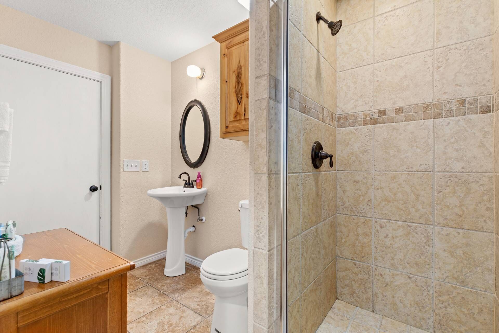 A bathroom with a sink, toilet, and shower area.