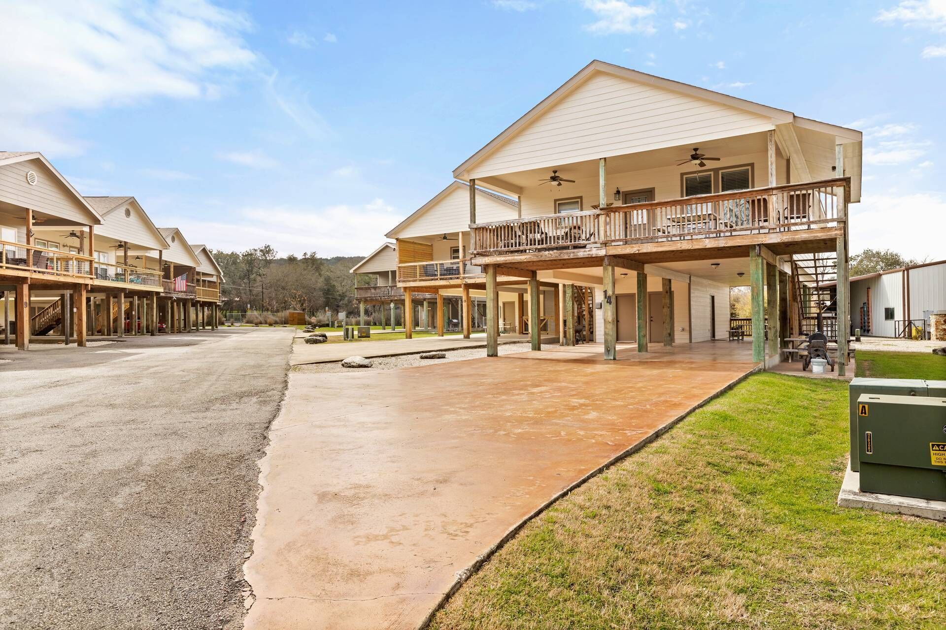 A hotel with multiple-story buildings, outdoor patios, and a covered parking area.