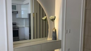 A modern bathroom with a vanity, a mirror, and a vase with flowers.