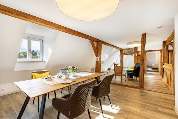 Un comedor con una mesa de madera, sillas y vistas al exterior.