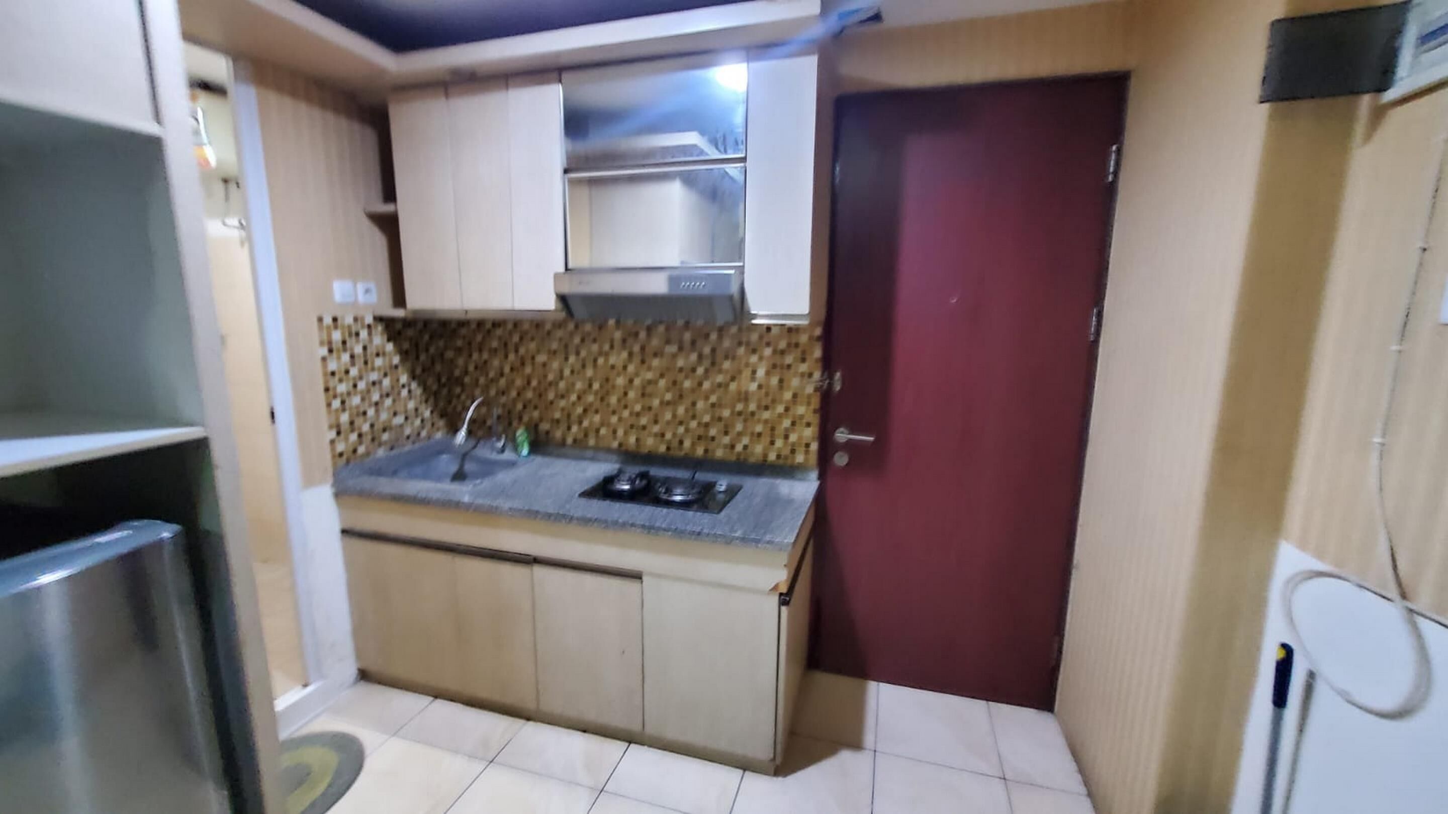 A compact kitchen with a gas stove, a sink, and a microwave.