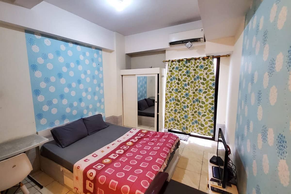 Ein Schlafzimmer mit Bett, Schreibtisch und Kleiderschrank.
