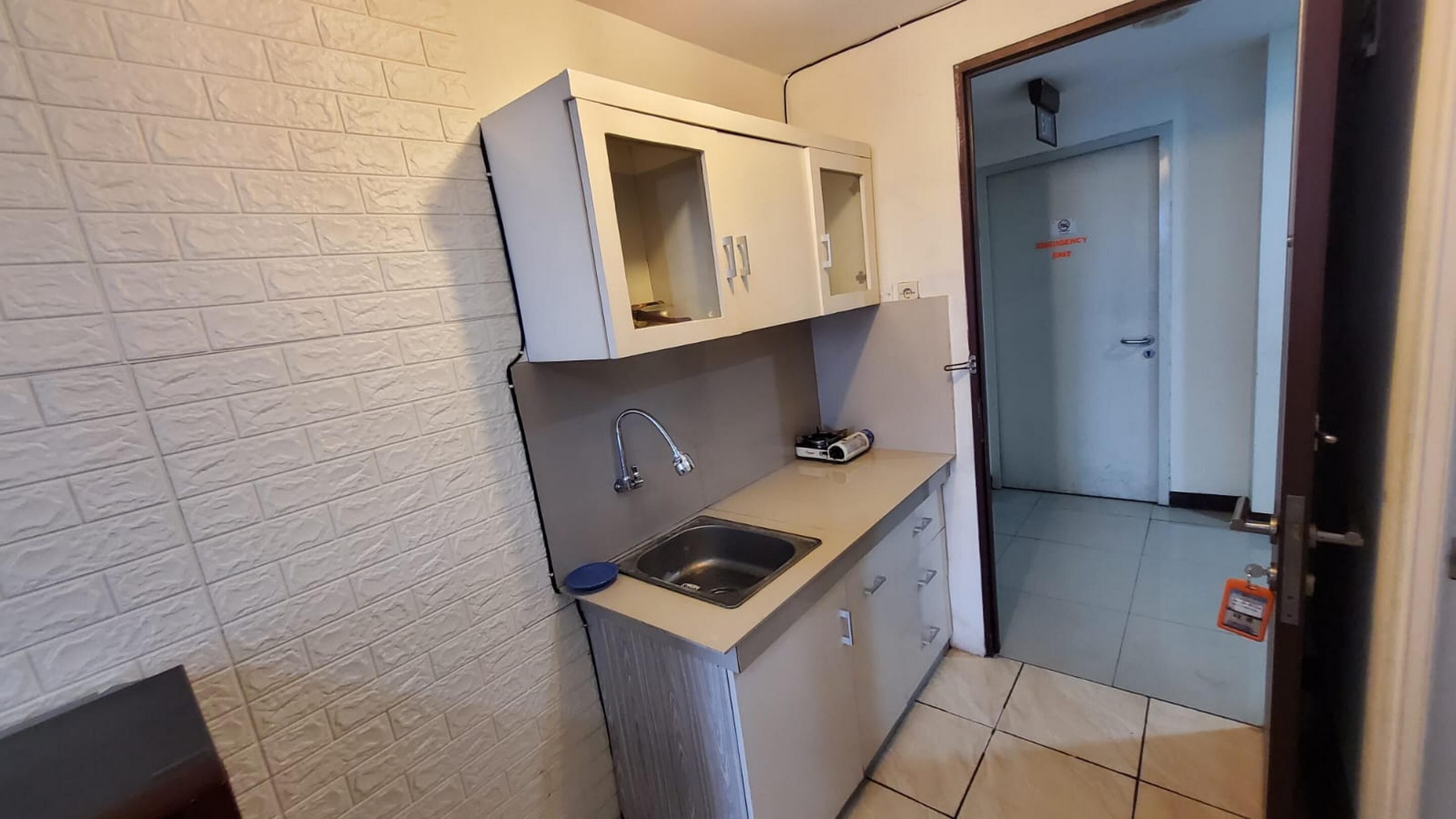 A small kitchen with a sink, a stove, and cabinets.