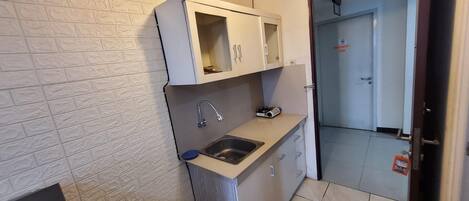 A small kitchen with a sink, a stove, and cabinets.