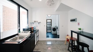 Een moderne keuken met een spoelbak, een raam en uitzicht op een wasruimte.