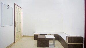 Una habitación con una puerta blanca, una pequeña mesa y un banco.
