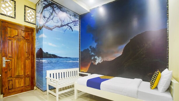 Una habitación con cama, una puerta de madera y un mural con una playa.
