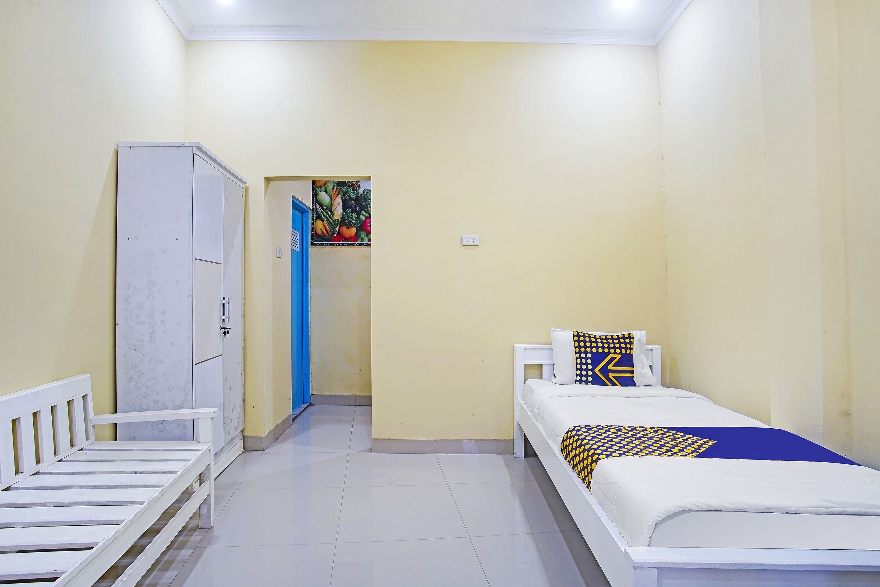Una stanza con un letto, un armadio e una porta che dà su un'altra stanza.