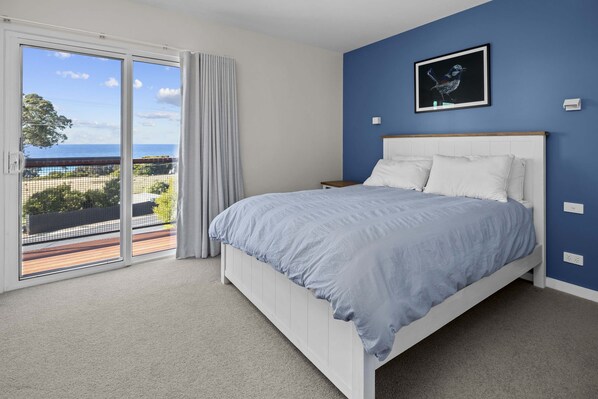 A bedroom with a bed, a view of the outdoors, and a painting on the wall. - RARE Views - Diamond Skies - Incredible! (Glamorgan-Spring Bay)