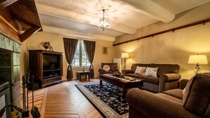 A cozy living room with a fireplace, a television, and comfortable seating.