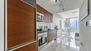 Een moderne keuken met houten kastjes, roestvrijstalen apparatuur en een ruimtelijk, licht interieur.