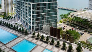A high-rise building with a swimming pool area, including two pools and a covered deck. - Apt 2505 · Brickell Icon STUDIO (Miami)