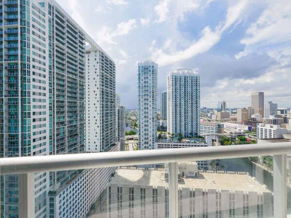 A high-rise building with a modern architectural design, featuring multiple floors with balconies and a glass facade.