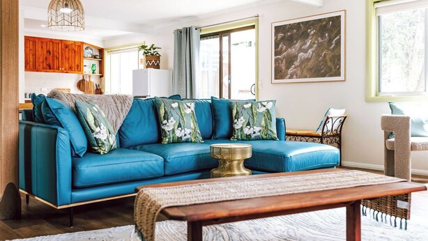 A living room with a blue sofa, a wooden coffee table, and a cat tree. - KAL's House - The place to be! (Glamorgan-Spring Bay)