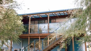Un bâtiment à deux étages doté d’un escalier en bois et d’un balcon.