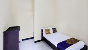 A small, clean room with a bed, a dresser, and a wall-mounted air conditioner. - OYO Life 93155 Wisma Sarah (Tanjung)