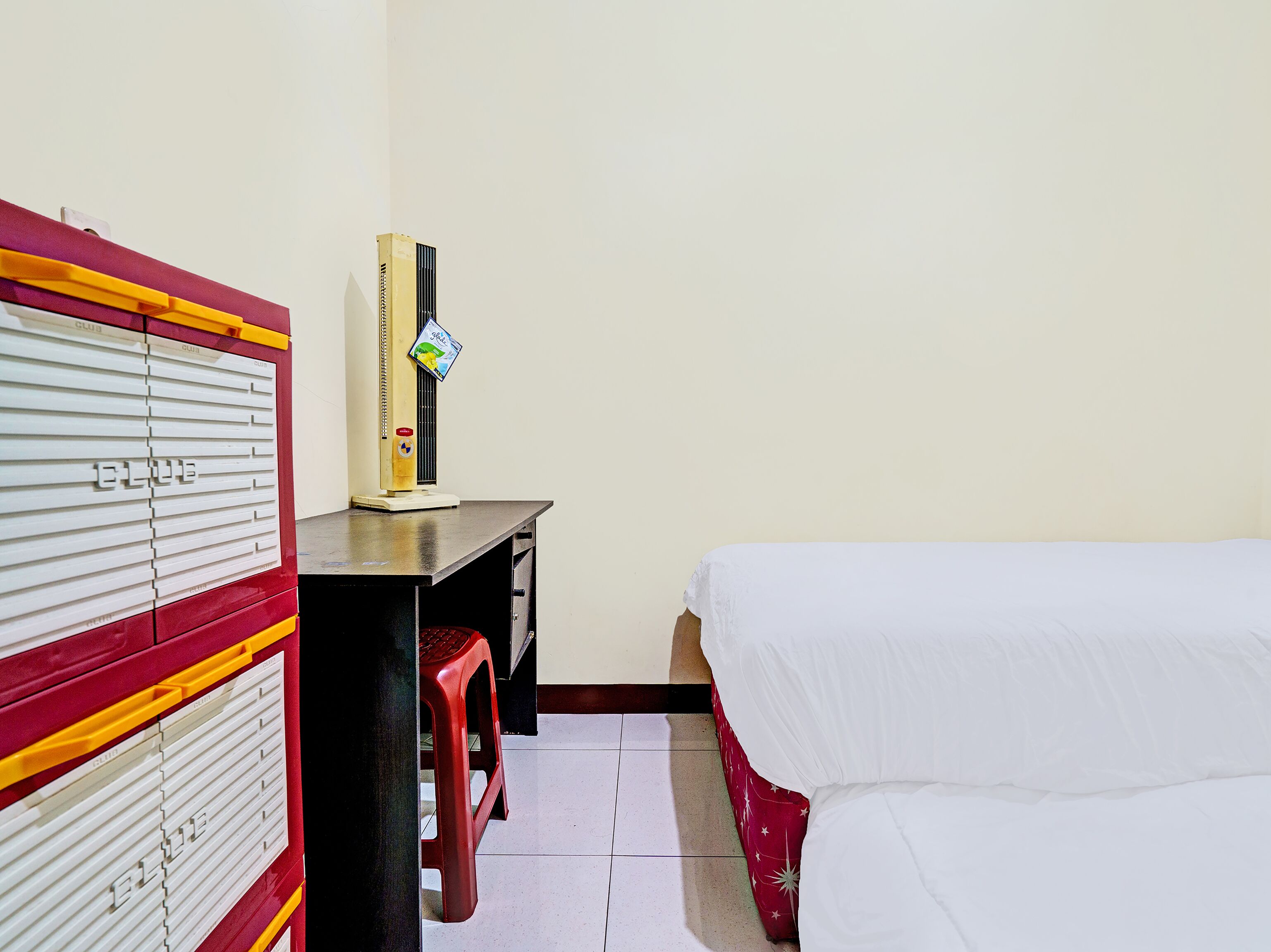 Une chambre d’hôtel comprenant un lit, un bureau avec une chaise, une armoire et un radiateur.