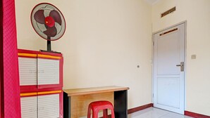 A room with a desk, a red stool, a fan, and a filing cabinet. - OYO Life 92546 Kost Merah Bojongsoang Syariah (Bojongsoang)