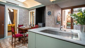 A compact kitchen with a sink, dining table, and chairs. - Belvedere Guastella B 4 Emma Villas (Noto)