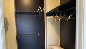 Een slaapkamer met een bed, een kledingkast en een klein bureau.