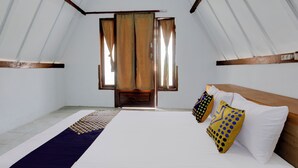 Una habitación con cama, cortinas y un tapiz estampado.