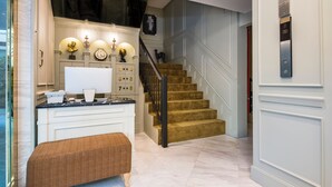 Um interior moderno com escada, uma mesa com computador e um banco.