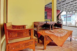 Un coin repas avec des meubles en bois et une table recouverte d’une nappe à motifs.