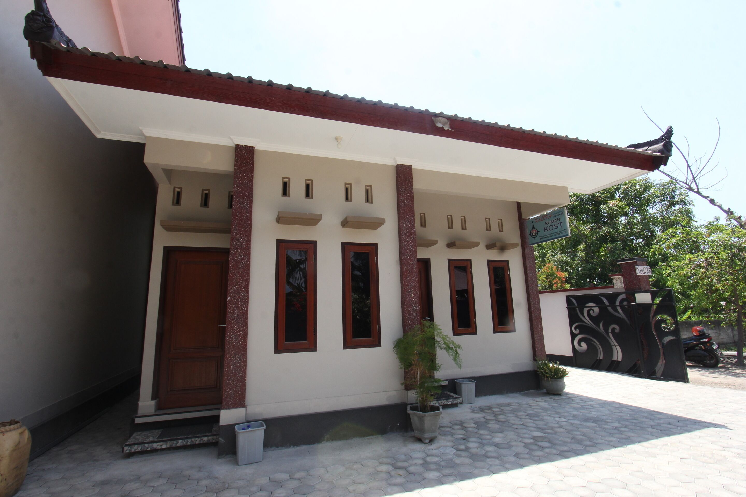 A building with a tiled entrance, a covered porch, and a gate.