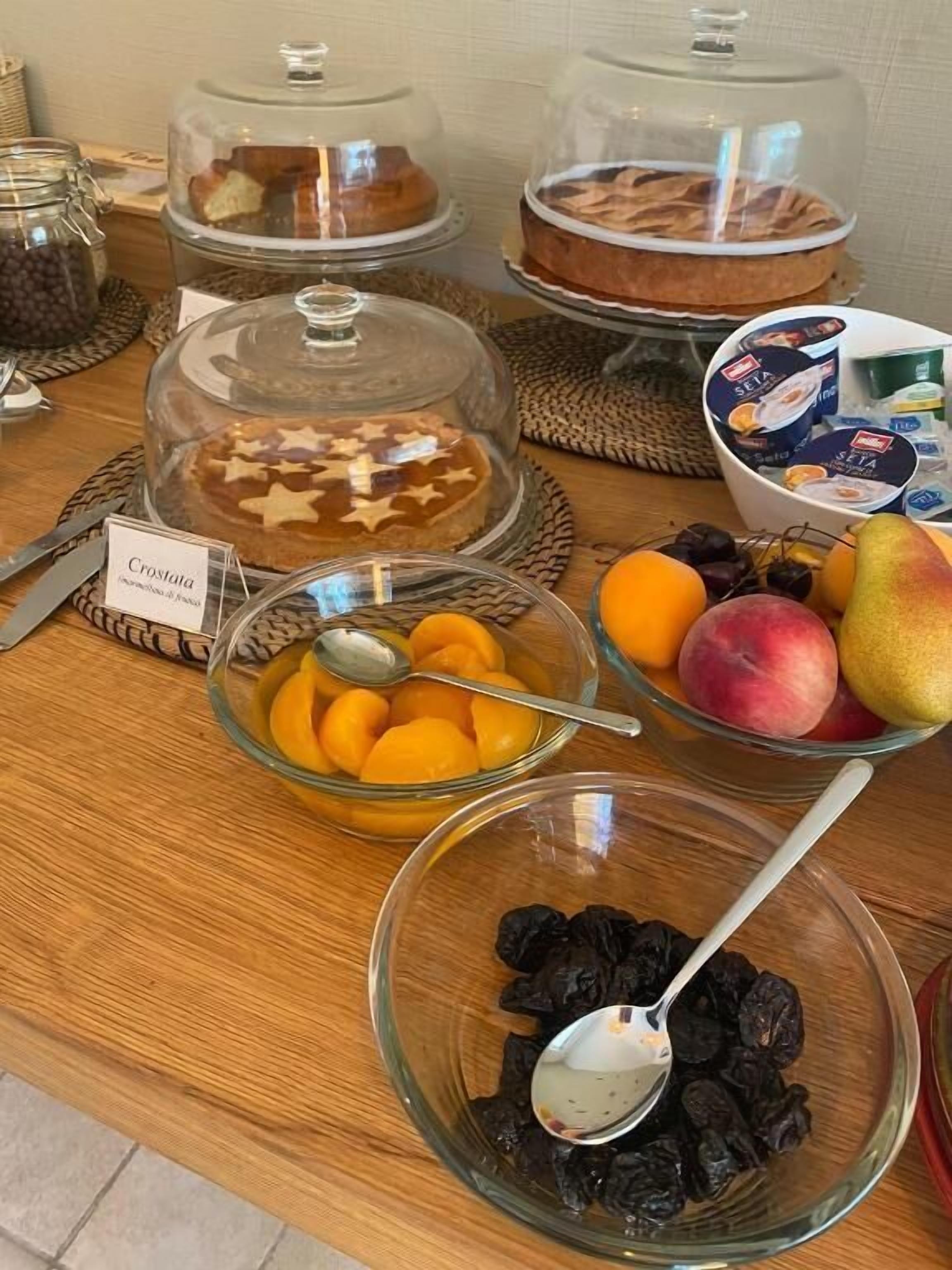 A breakfast buffet with various food items including croissants, fruits, and yogurt.