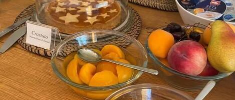 A breakfast buffet with various food items including croissants, fruits, and yogurt.