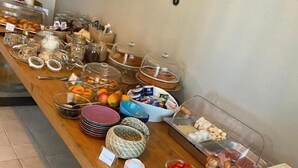 Un tavolo da buffet con diversi cibi e utensili.