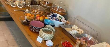 A buffet table with various food items and utensils.