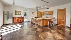 Une cuisine moderne dotée d’un îlot central, de meubles en bois et d’une grande fenêtre.