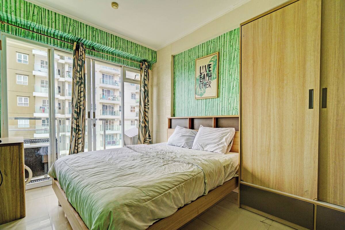 Une chambre à coucher avec un lit, une armoire et une fenêtre avec des rideaux.