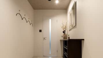 A hallway with a tiled floor, a dark wooden counter, and a door at the end.