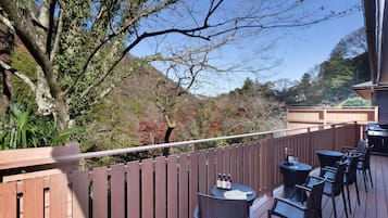 A deck with outdoor seating and a view of a mountainous landscape.