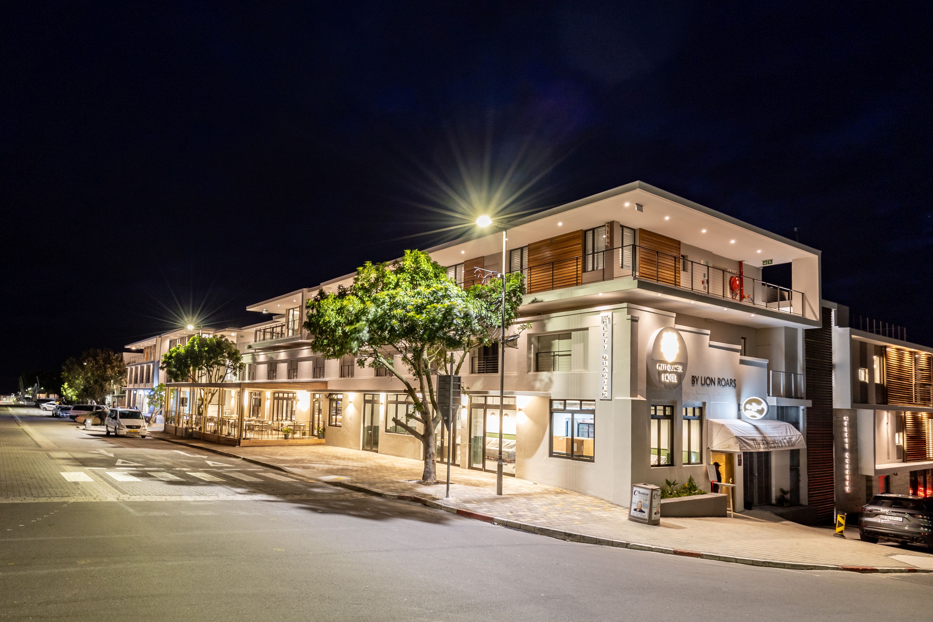 Un hotel moderno con una fachada bien iluminada, ventanas grandes y una entrada visible.
