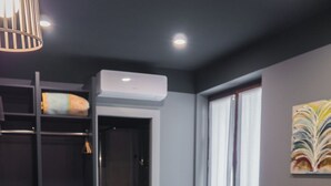 A hotel room with a bed, a built-in wardrobe, a window with curtains, and a wall-mounted air conditioner. - Host'n GO (Colleferro)