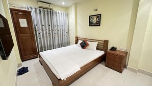 Un dormitorio con una cama de madera, una mesita de noche, un armario y una cortina.