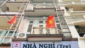 Un edificio con un cartel que dice 'NHA NGHI (TRG)' y 'TUAN ANH'.