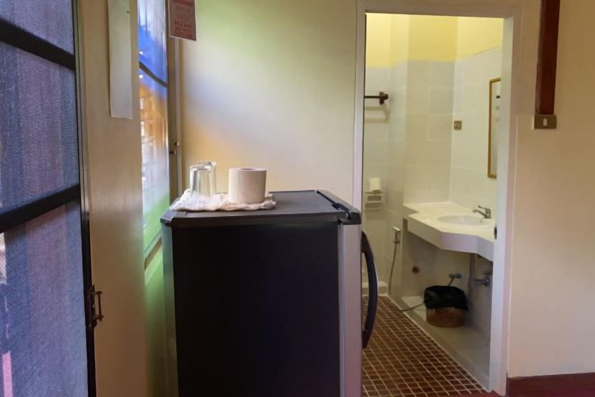 A bathroom with a sink, mirror, and a trash bin.