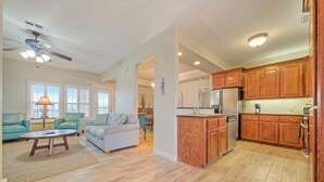 A spacious living area with a sofa, coffee table, and a ceiling fan. - Walk to the Beach | Golf Cart Rental, Beach Boardwalk, Balcony Views | AvantStay (Port Aransas)