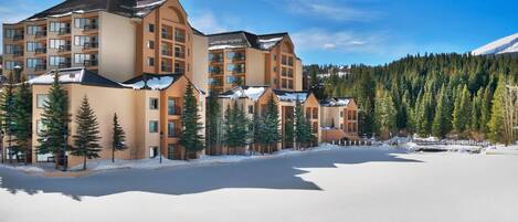 A multi-story hotel with a modern architectural design, featuring balconies and large windows.