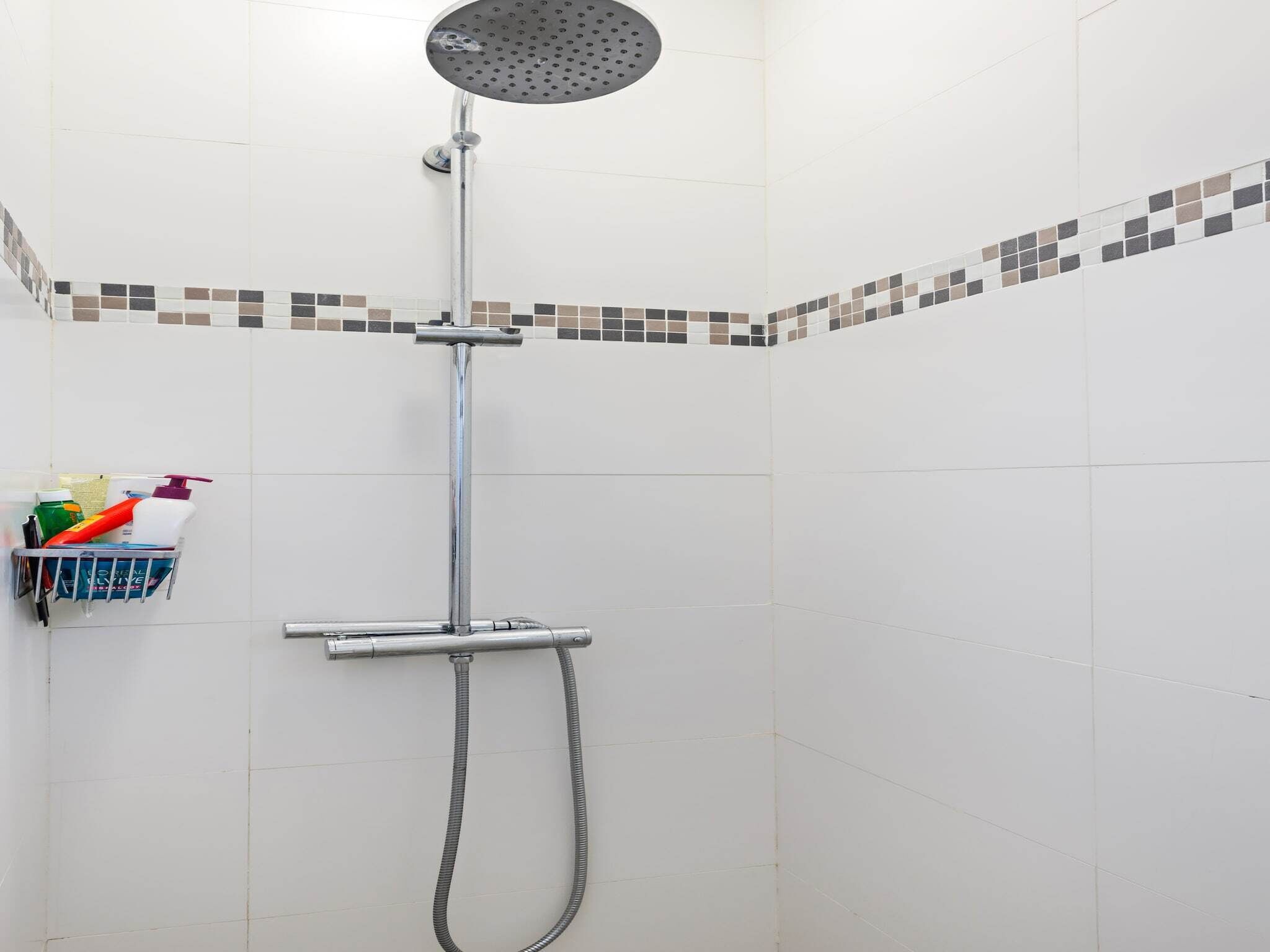 A shower with a handheld showerhead and a flexible hose.