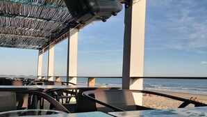 Un restaurant situé en bord de mer, avec une terrasse offrant une vue sur l’océan.