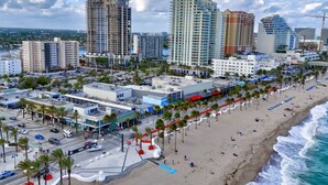 A coastal cityscape with high-rise buildings, a beach with palm trees, and a marina. - Lux Villa - 3br/2ba off Las Olas (Fort Lauderdale)