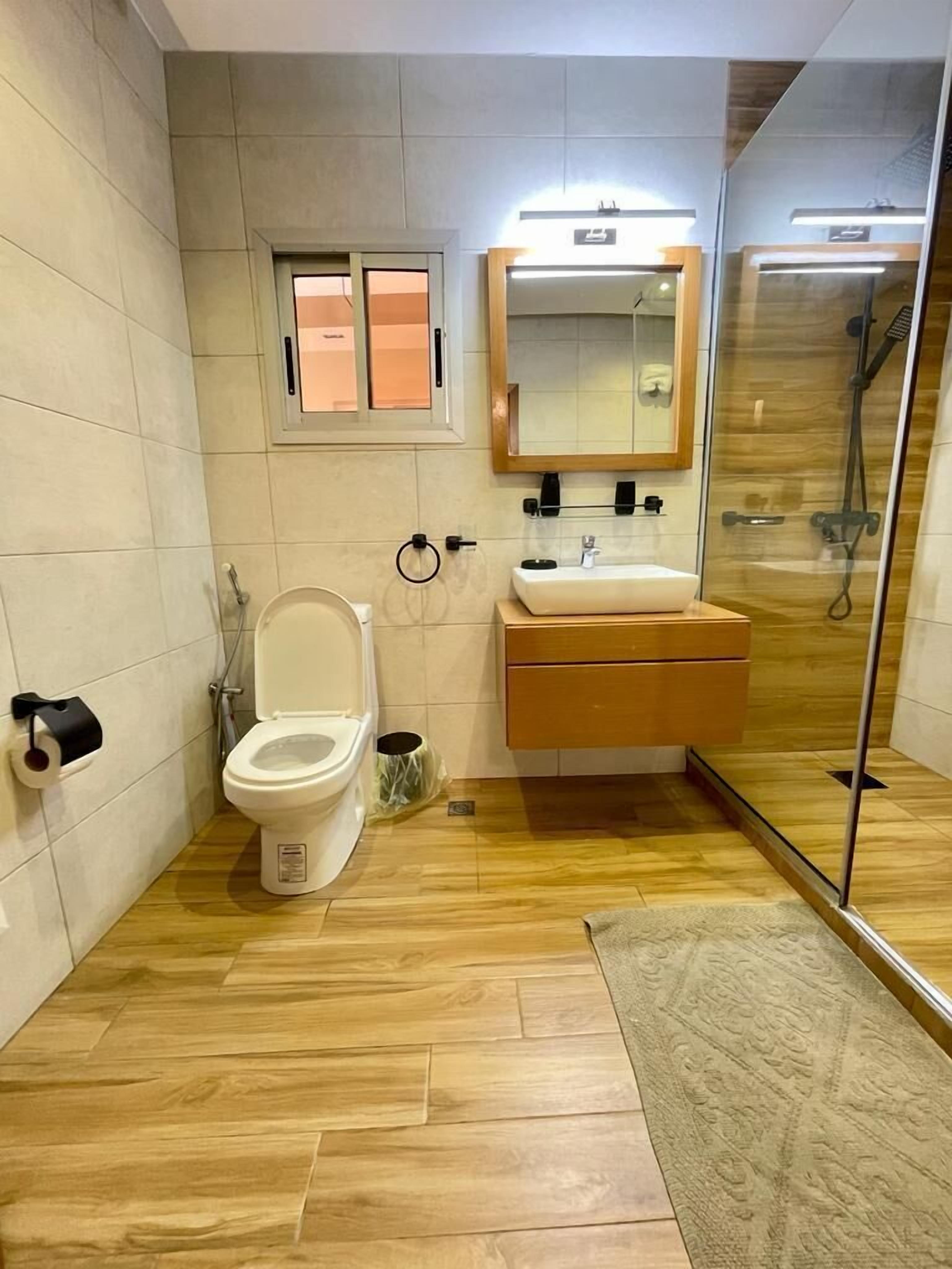 A modern bathroom with a toilet, sink, and shower.