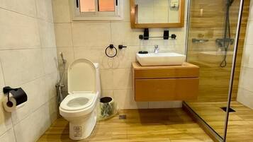 A modern bathroom with a toilet, sink, and shower.