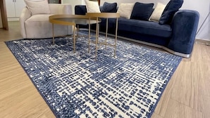 A modern living room with a sofa, a coffee table, and a patterned rug. - Swanky  Apartments (Douala)